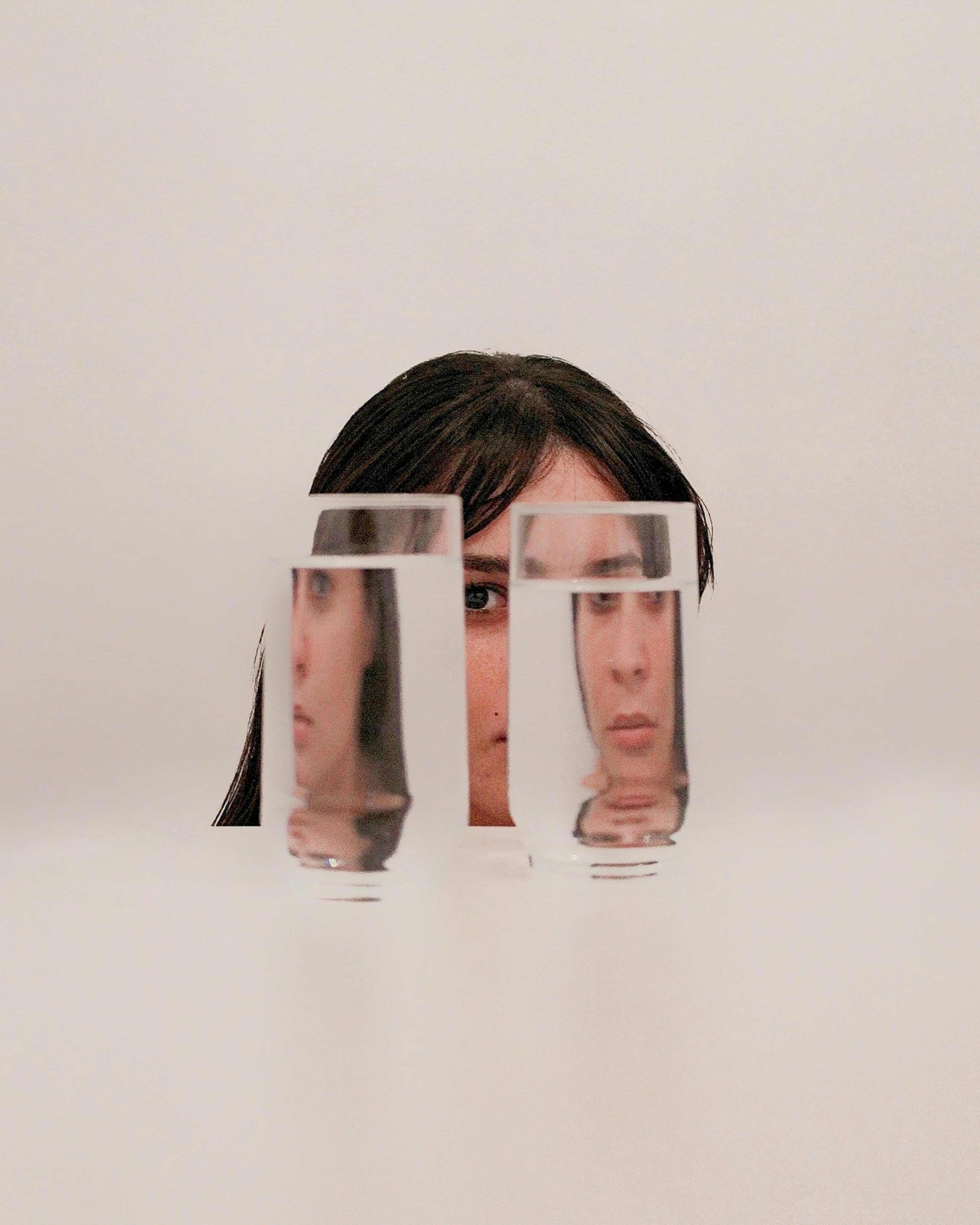 Woman gazing through two glasses of water
